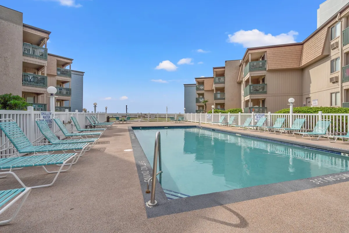 A vibrant swimming pool surrounded by lounge chairs and balconies, with a lively yet relaxed atmosphere. The scene suggests a welcoming resort setting ideal for swimming, sunbathing, and socializing, reflecting the sunny, communal spirit described in the section.